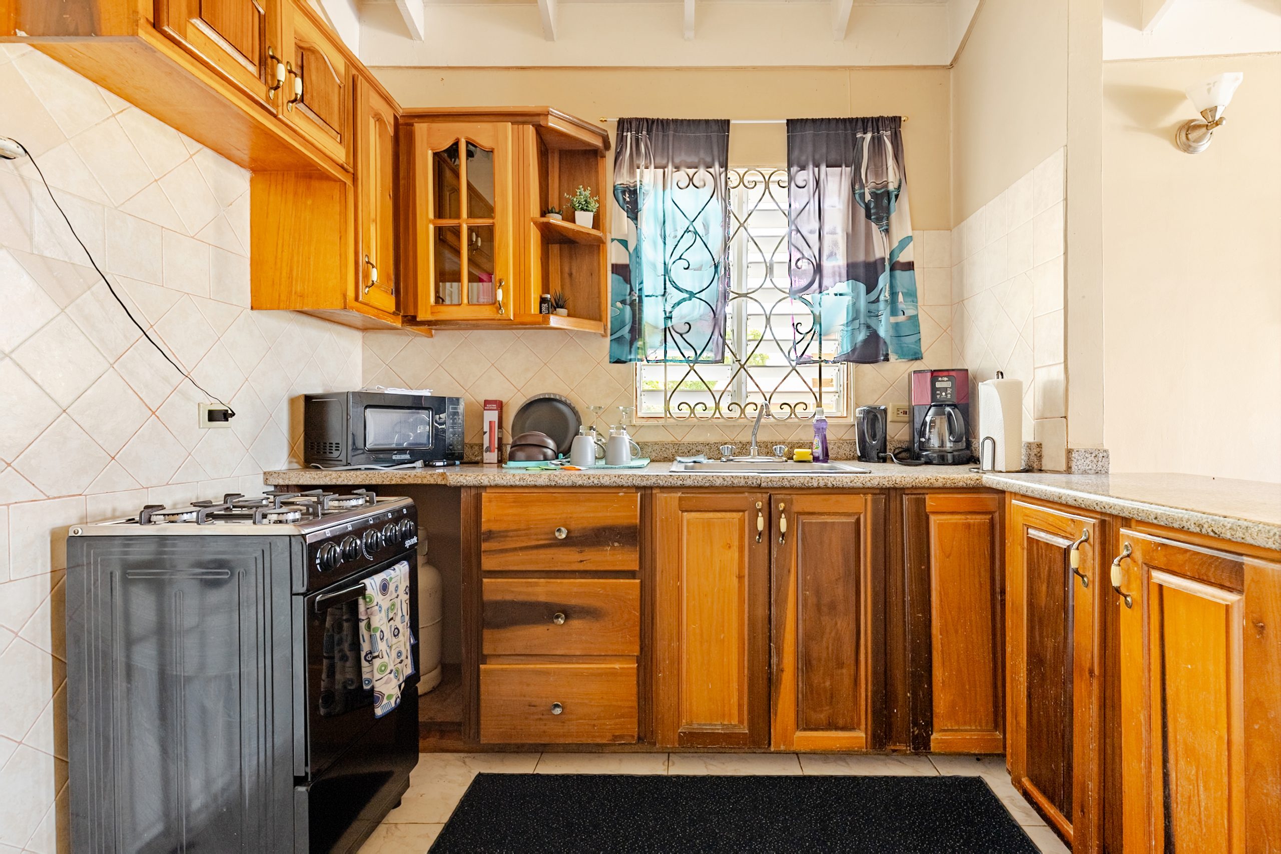 The equipped kitchen with wooden cabinets and a breakfast bar